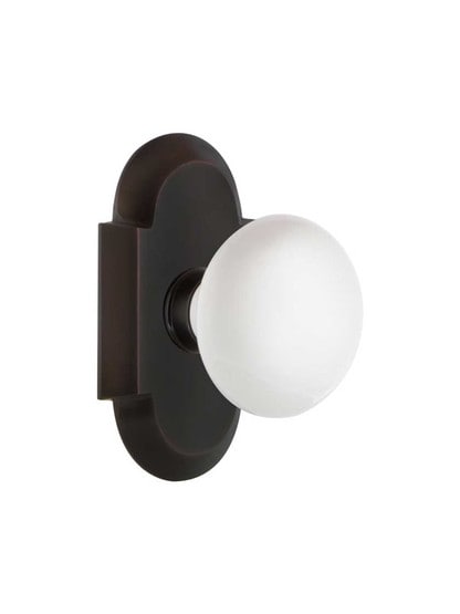 Arched Rosette Door Set with White Porcelain Knobs in Timeless Bronze.